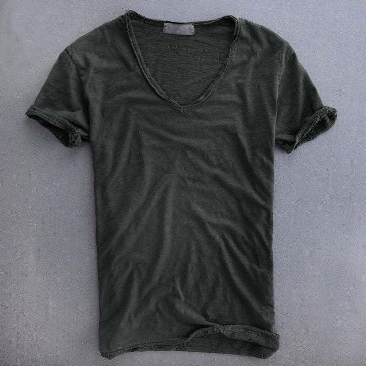 Donkergrijs T-shirt met V-hals en omgeslagen mouwen, plat neergelegd op een grijze ondergrond, met een subtiele getextureerde stof. 4