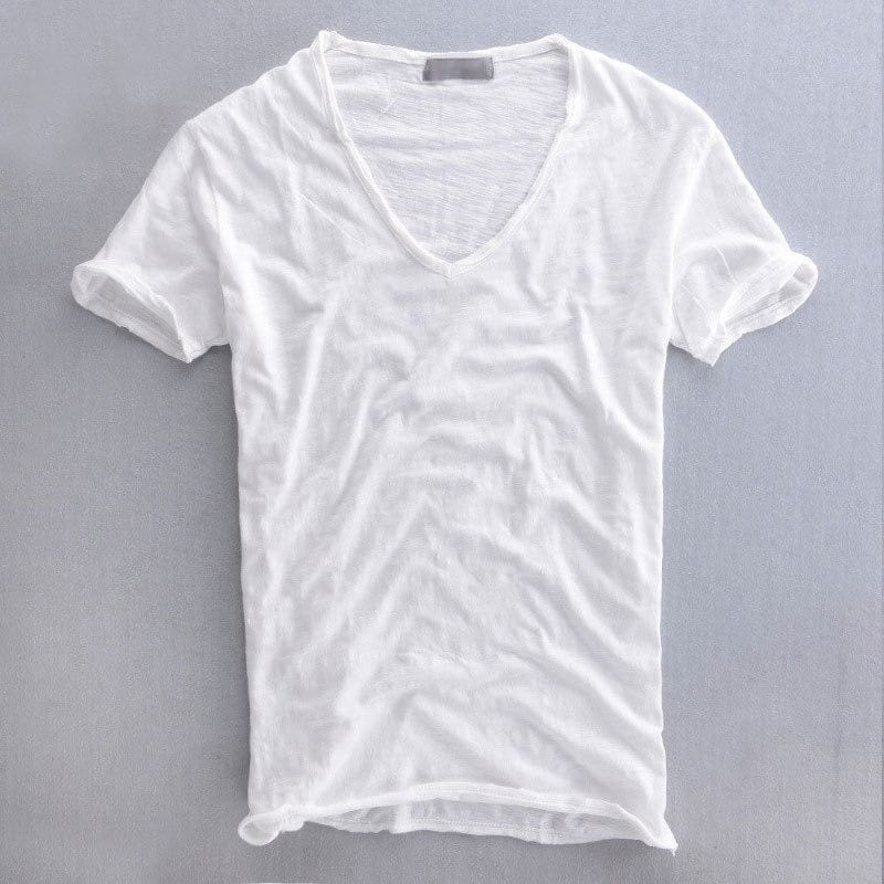 Wit T-shirt met V-hals en omgeslagen mouwen, plat neergelegd op een grijze ondergrond, met een vlammige textuur in de lichte stof. 2