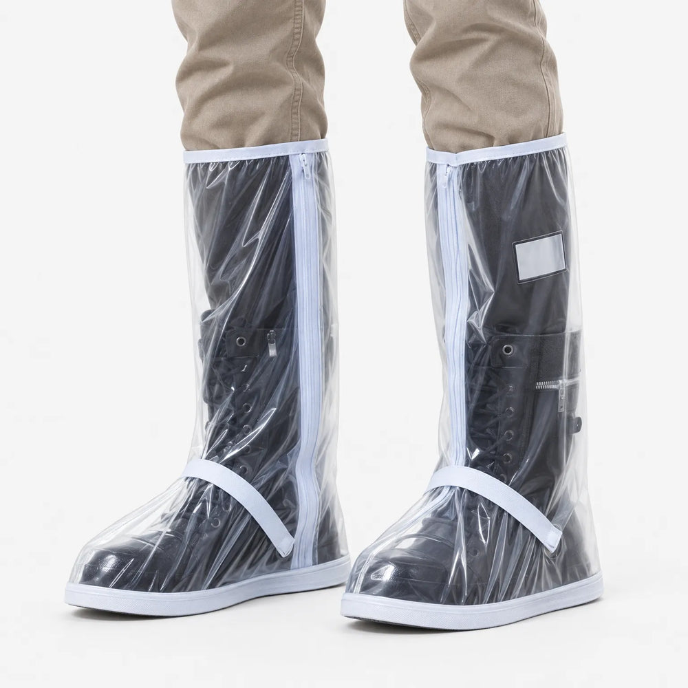 Doorzichtige regenoverschoenen met witte rits en bandjes, over zwarte veterlaarzen gedragen, gezien van voren tegen een witte achtergrond. 2