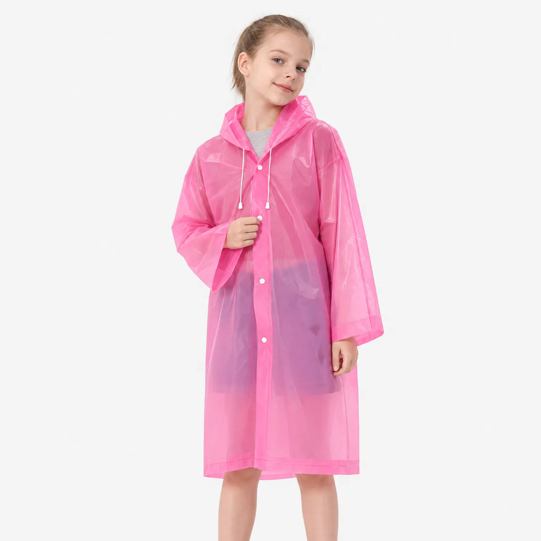 Meisje in roze doorschijnend regenjack met capuchon en witte koordjes, dichtgeknoopt, kijkt glimlachend in de camera. 4