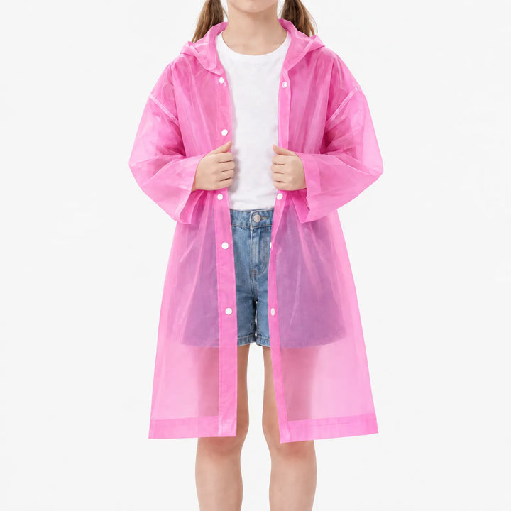 Meisje draagt het roze doorschijnende regenjack open over wit shirt en spijkershort, met drukknopen zichtbaar. 8