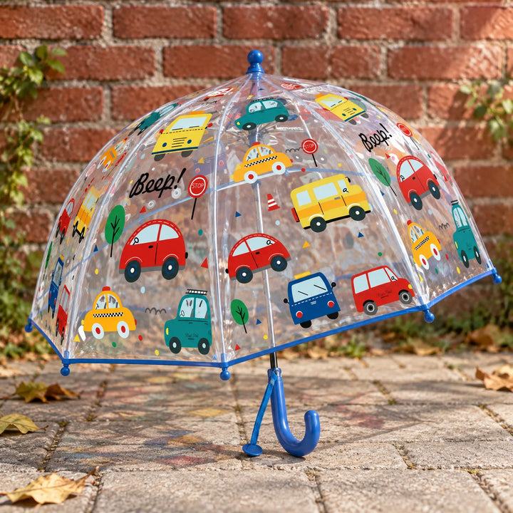 Doorzichtige koepelparaplu met kleurrijke autootjes en blauw handvat, buiten op straatstenen voor een bakstenen muur. 3