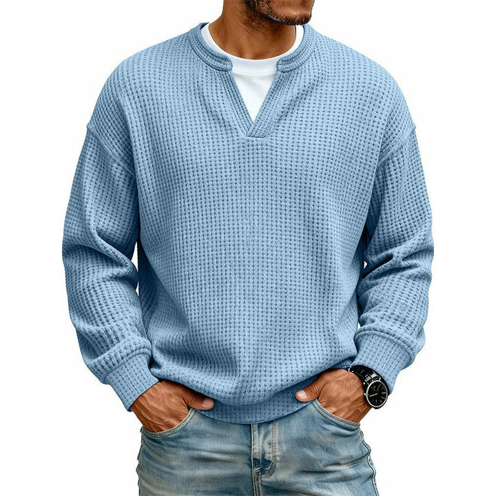 Dezelfde wafeltrui in lichtblauw, gedragen door een model met wit shirt eronder en een spijkerbroek. 6