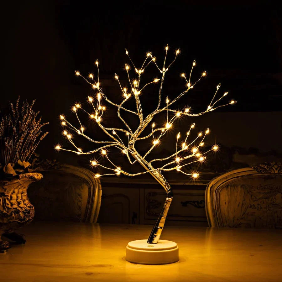 Boomlamp met warm licht en ronde witte voet op een tafel, naast een vaas 2