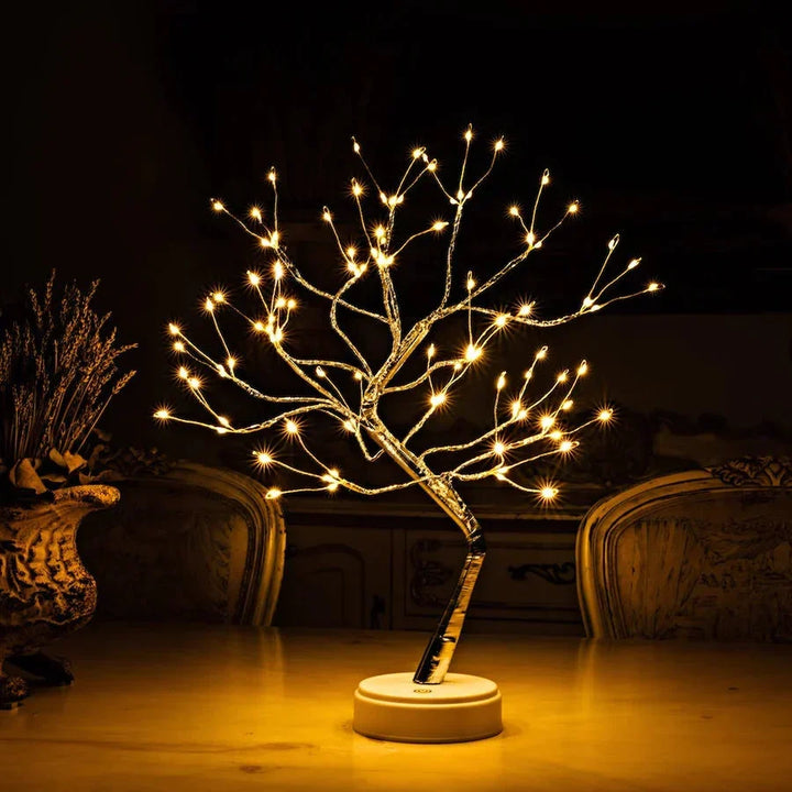 Boomlamp met warm licht en ronde witte voet op een tafel, naast een vaas 2