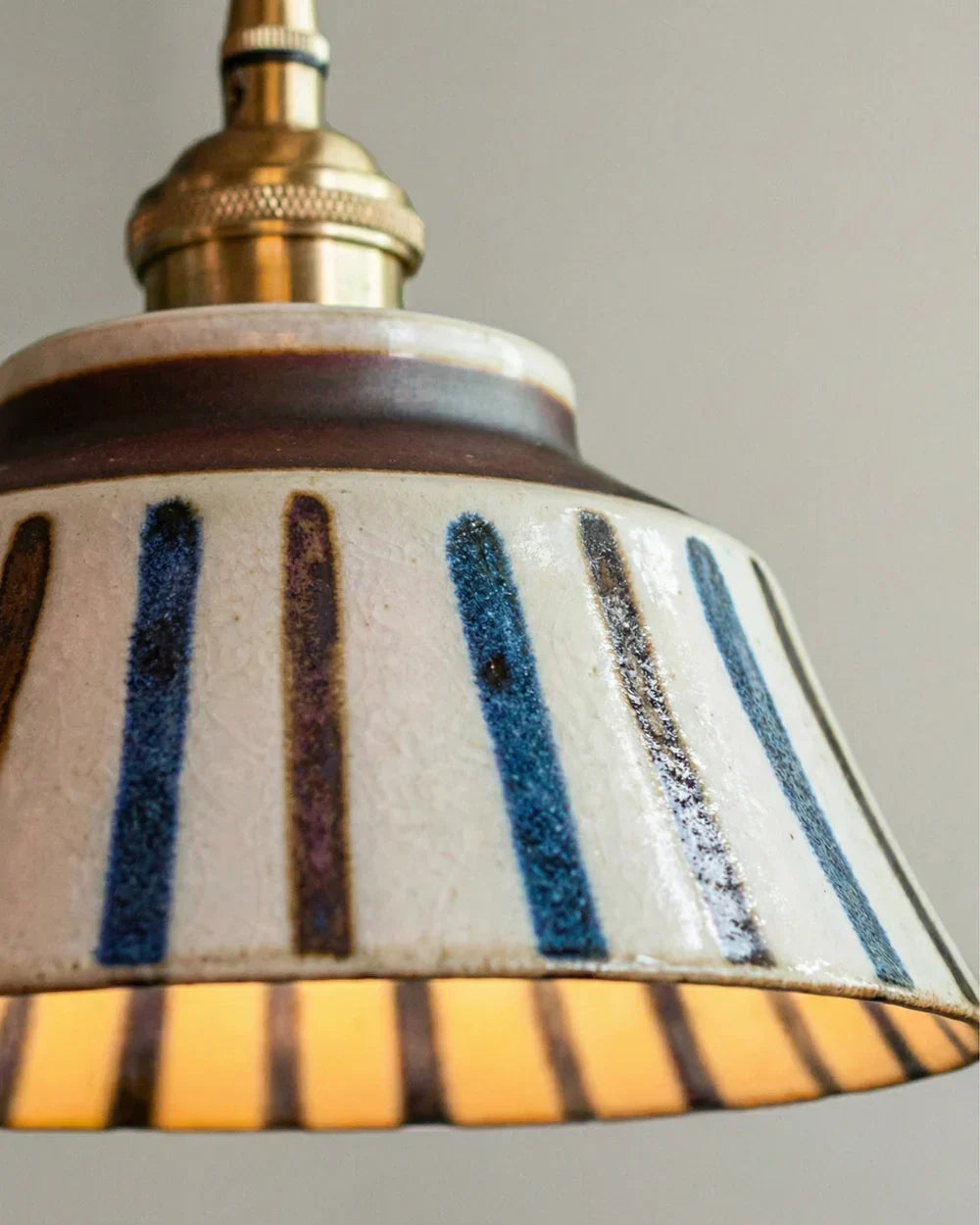 Close-up van de gestreepte keramische kap met blauwe en bruine streepjes, bruine rand, craquelé glazuur en messing fitting. 7
