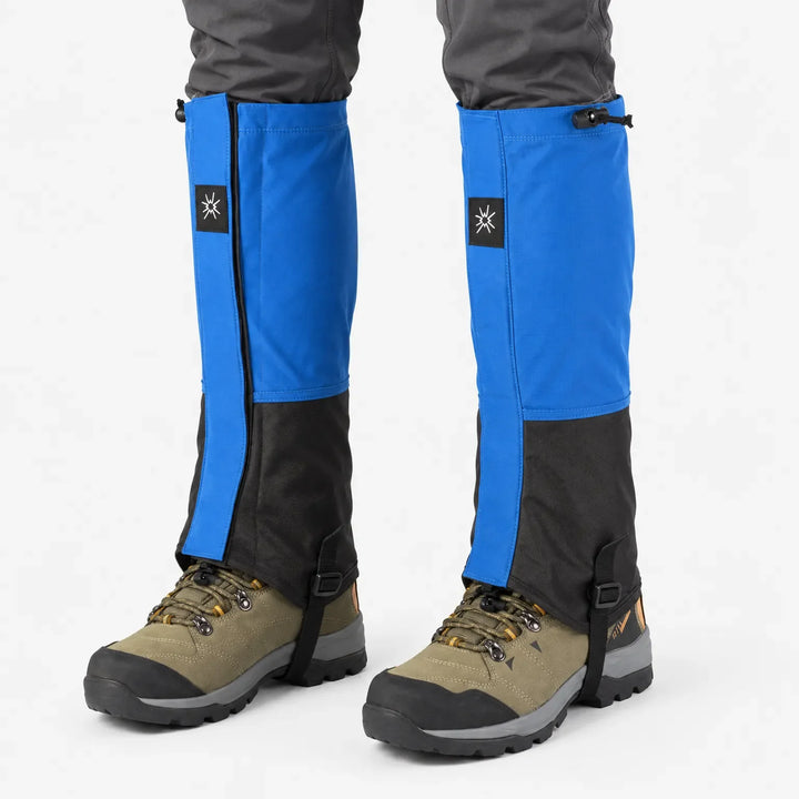 Blauwzwarte loopgamashen frontaal gedragen boven olijfgroene wandelschoenen, met koordsluiting bovenaan en bandje onder de schoen. 7