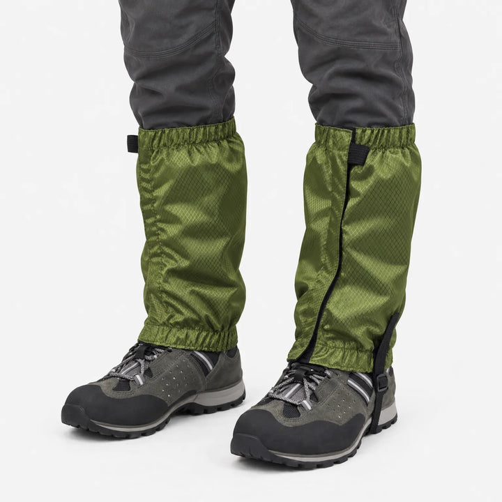 Olijfgroene gamaschen met ruitjesstructuur, gedragen over grijze wandelschoenen, getoond op een witte achtergrond. 2