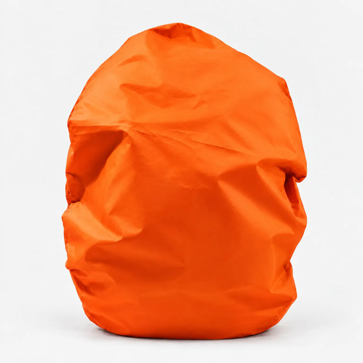 Rugzakhoes in oranje, vrijstaand op een witte achtergrond, over een gevulde rugzak getrokken. 9