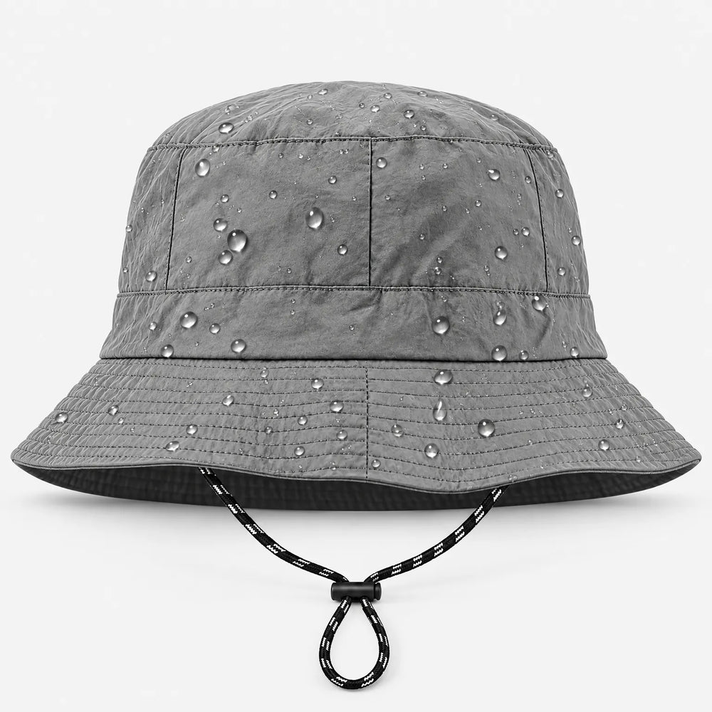 Grijze bucket hoed van voren met regendruppels die op de stof liggen en een zwart-wit koordje onder de rand. 2