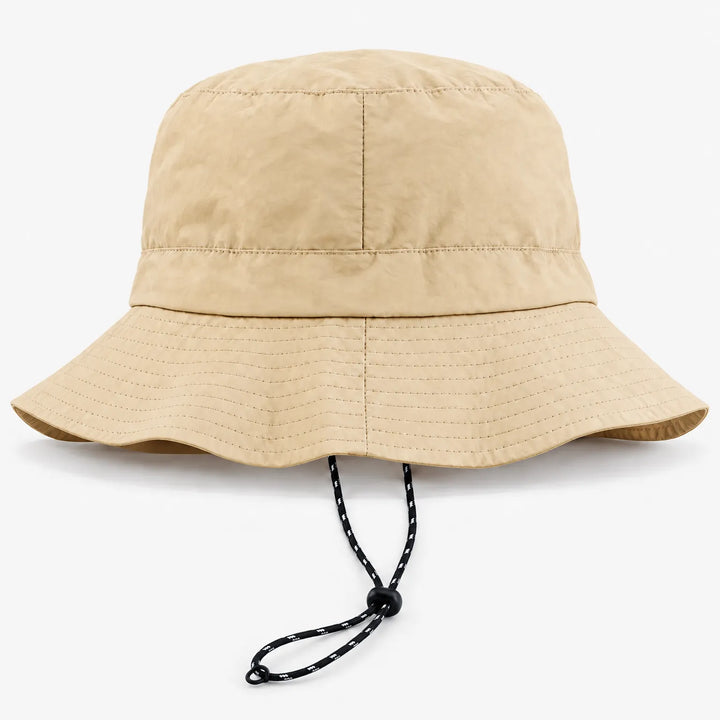 Beige bucket hoed met brede rand van voren, met zwart-wit koordje met stopper eronder. 7