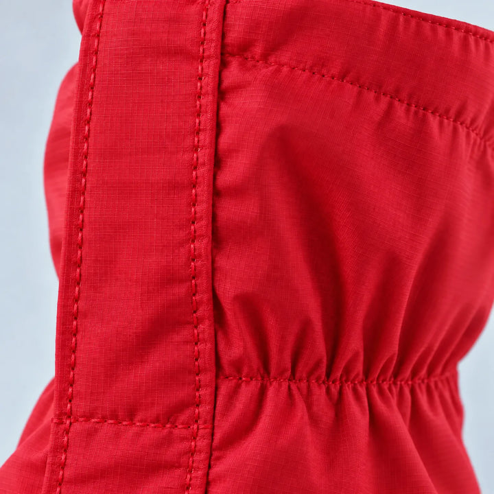 Detail van de rode stof met ripstopstructuur, stikwerk en elastische plooien van de gaiter. 6