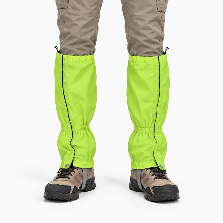 Voorkant van felgroene gaiters over een beige broek en bruine wandelschoenen, met zijrits en drukknoop. 7