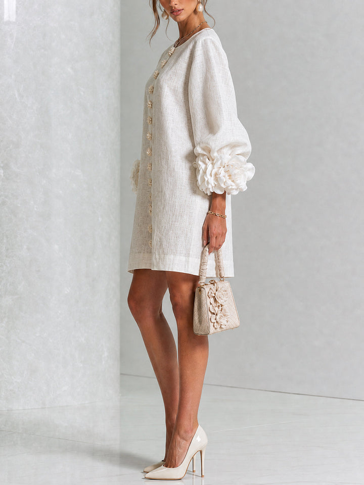 Crèmewitte jurk van opzij gefotografeerd op een model met beige handtas en pumps, de roosmanchet op de pofmouw goed zichtbaar. 2