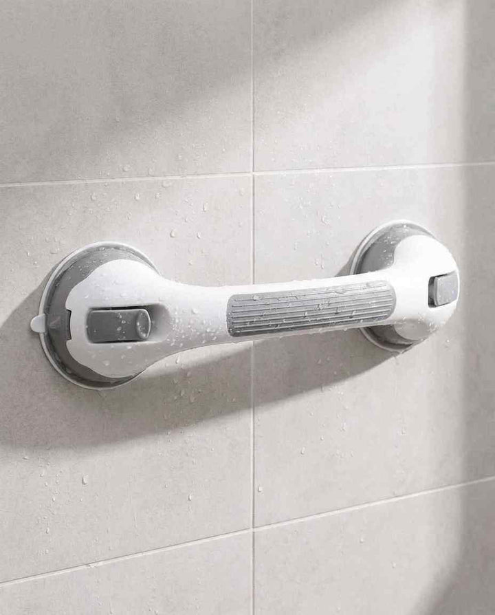 Beugel met grijze antislipgreep aan een beige tegelwand, bespat met waterdruppels alsof hij net onder de douche heeft gehangen. 14