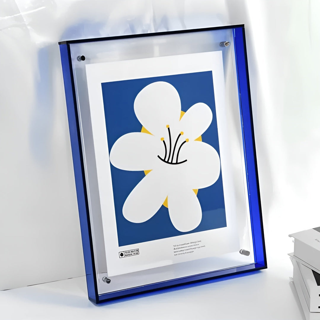 Blauwe acryllijst met doorzichtige voorkant en bevestigingsschroefjes, schuin tegen een lichte muur, met een poster van een grote witte bloem op blauwe achtergr 14