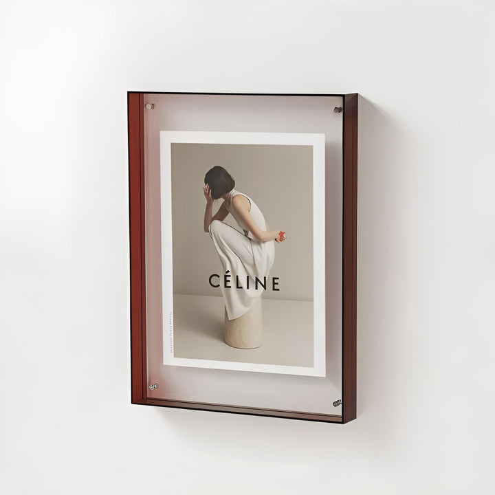 Acryllijst met roodbruine zijkanten aan een witte muur, schuin gezien, met een fotoprint van een gehurkte vrouw in witte kleding. 20