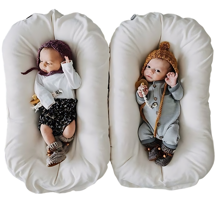 Twee baby's met mutsjes liggen naast elkaar in twee crèmekleurige ligstoelen 5
