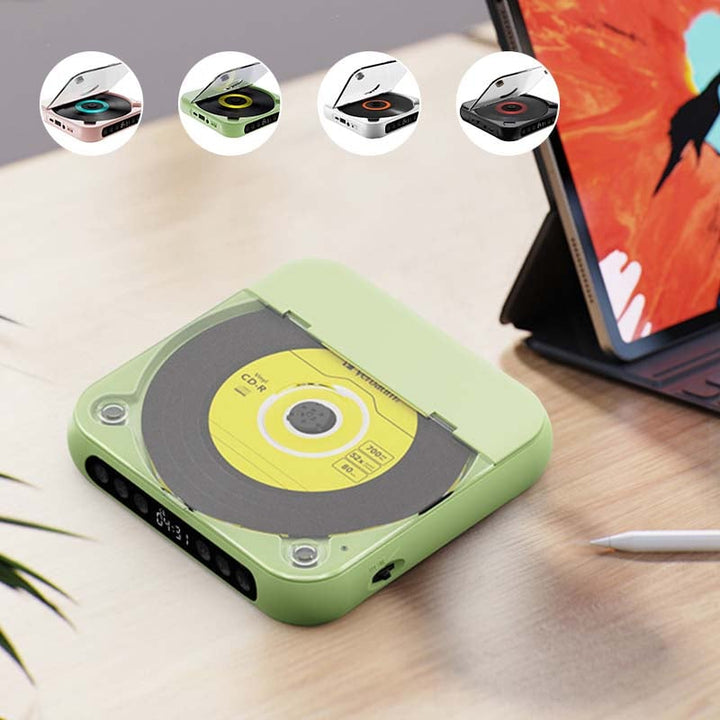 Groene cd-speler op een houten bureau naast een tablet, met bovenin vier kleine voorbeelden van de beschikbare kleuren. 6