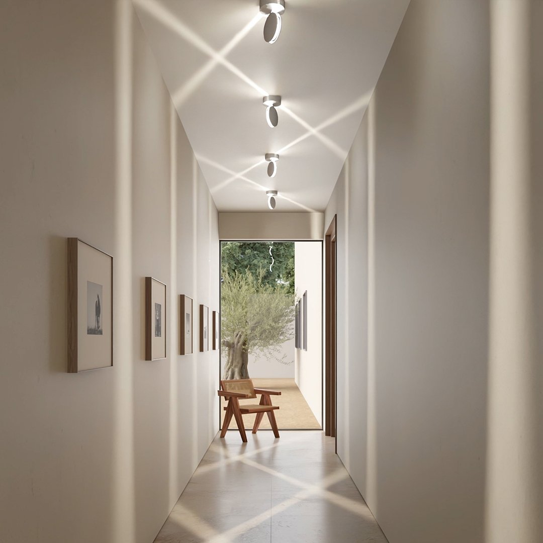Gang met plafondlampen die gekruiste, diagonale lichtbundels op het plafond en de vloer vormen, onder zacht daglicht. 7