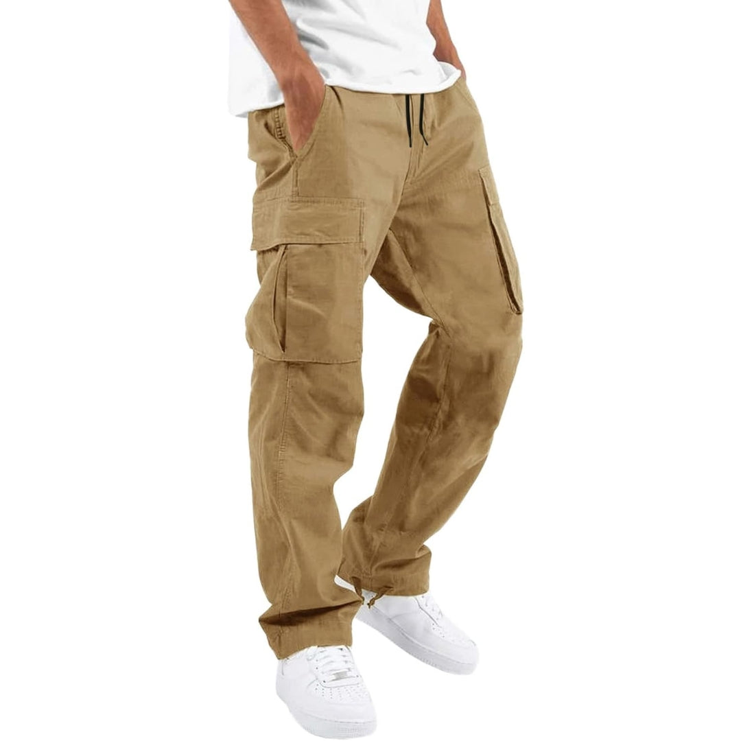 Model draagt kakikleurige cargobroek met handen in de zakken, zijzakken met klep en trekkoord, gecombineerd met wit T-shirt en witte sneakers. 7