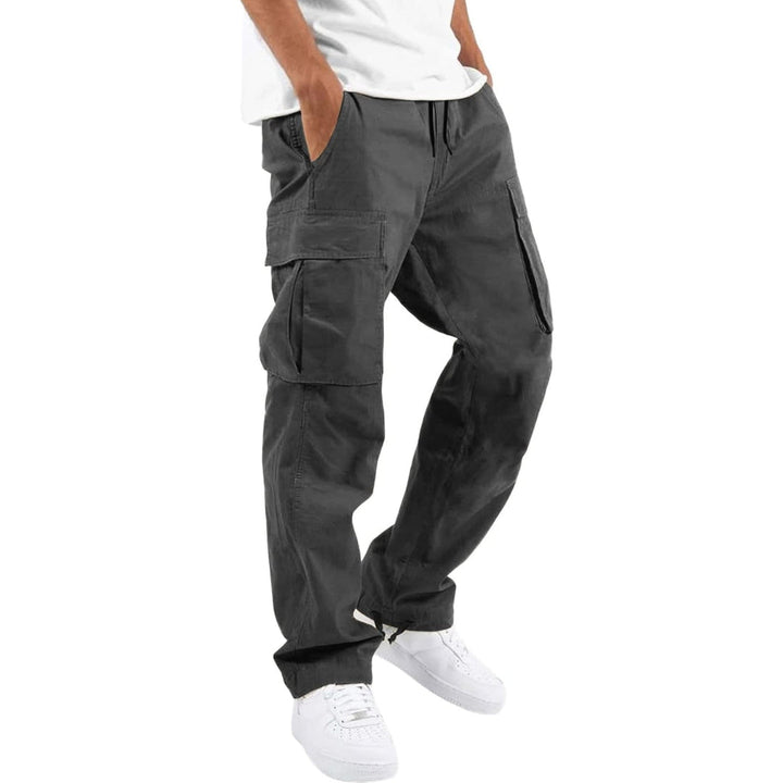 Model draagt donkergrijze cargobroek met handen in de zakken, zijzakken met klep en trekkoord, gecombineerd met wit T-shirt en witte sneakers. 8