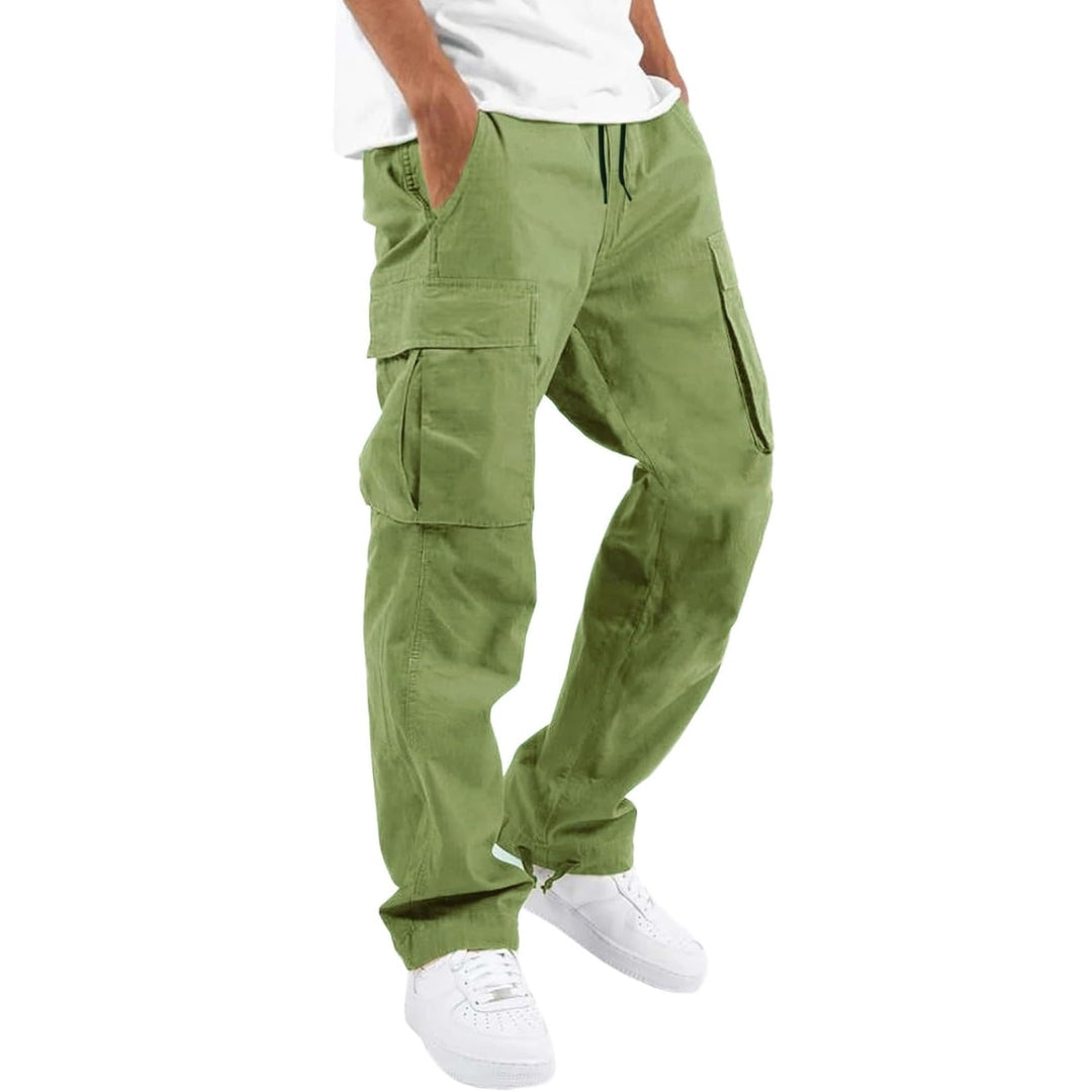 Model draagt lichtgroene cargobroek met handen in de zakken, zijzakken met klep en trekkoord, gecombineerd met wit T-shirt en witte sneakers. 9