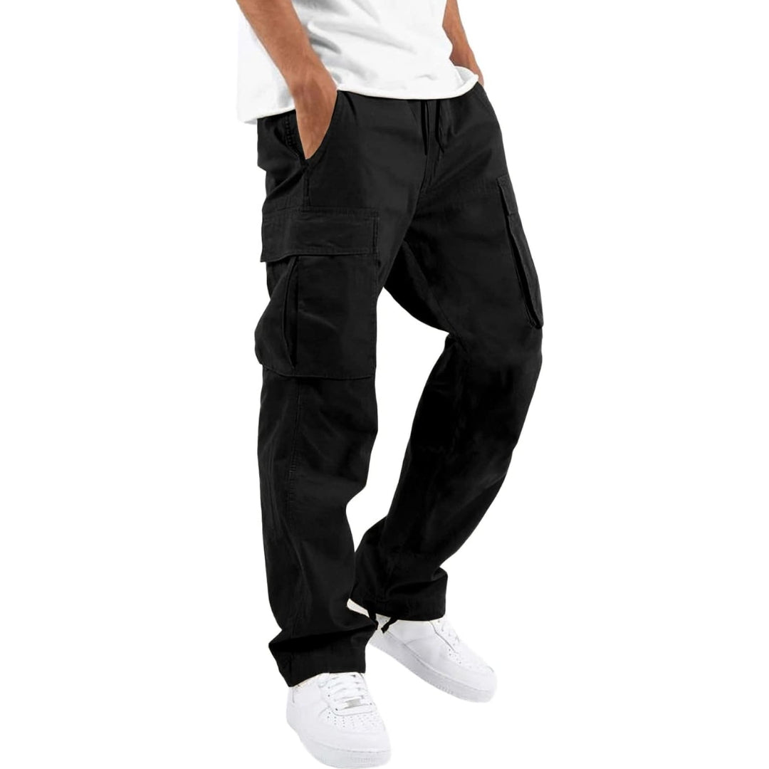 Model draagt zwarte cargobroek met handen in de zakken, zijzakken met klep en trekkoord, gecombineerd met wit T-shirt en witte sneakers. 4