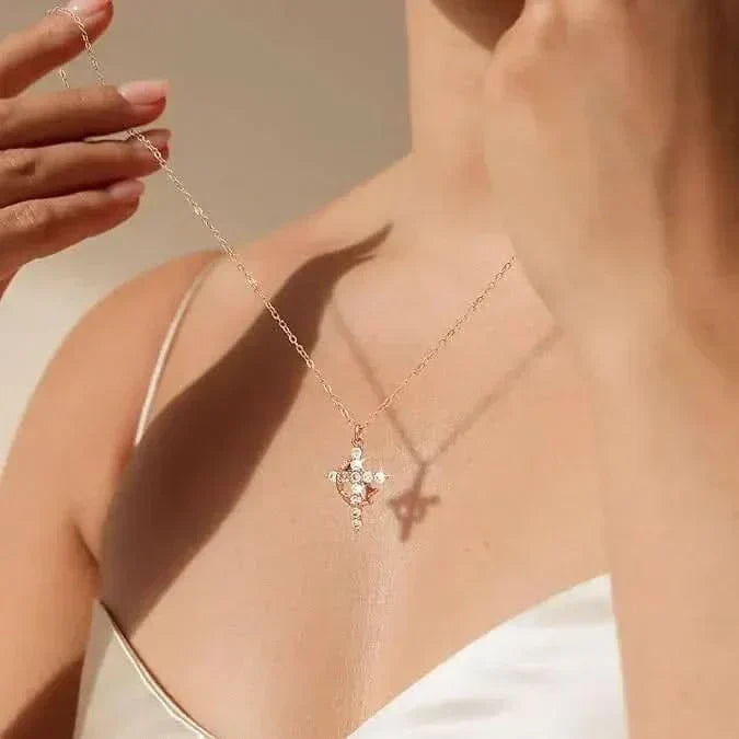 Model draagt de ketting met sprankelende kruishanger op haar decolleté terwijl ze de fijne schakelketting met één hand vasthoudt. 3