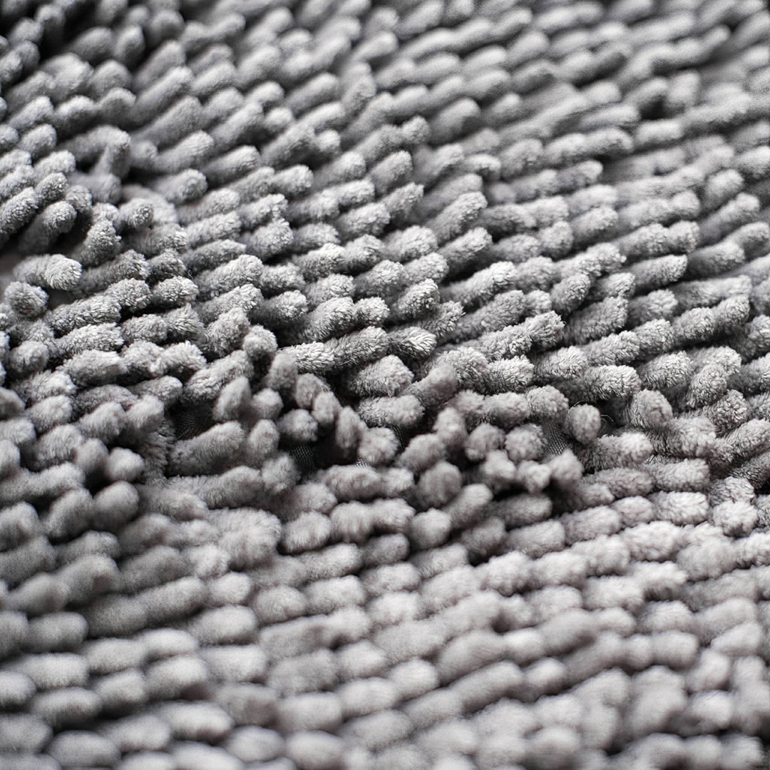 Close-up van de dikke, zachte grijze chenille vezels van de deurmat. 7