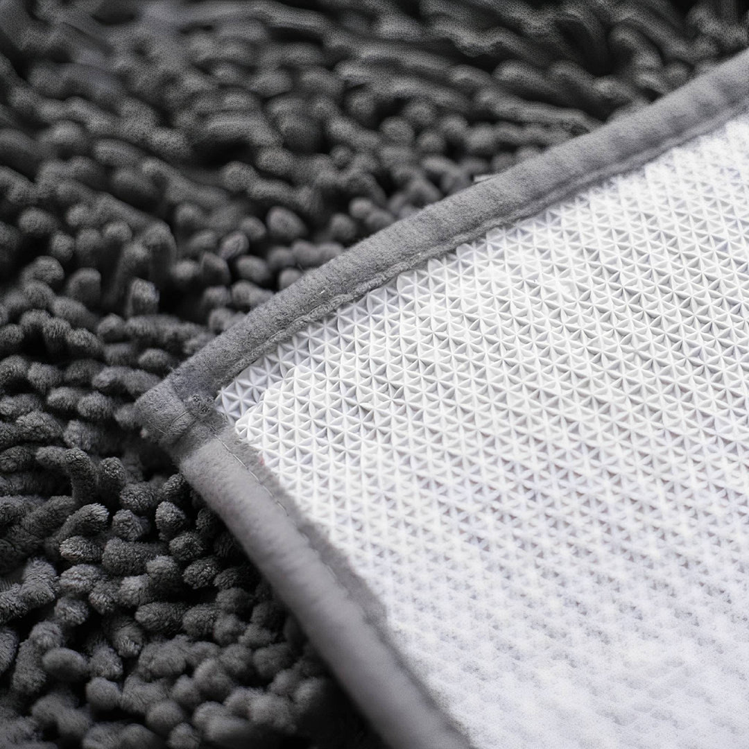 Close-up van de achterkant van de mat met witte antislip noppenlaag en een grijze rand. 8