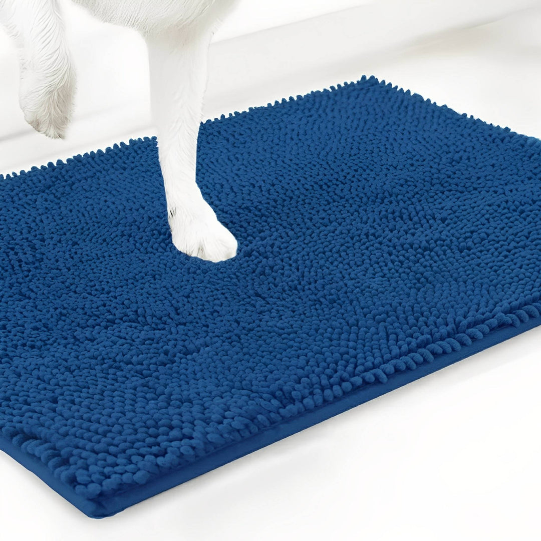 Blauwe chenille mat van dichtbij, met een witte hondenpoot die in de zachte vezels zakt. 17