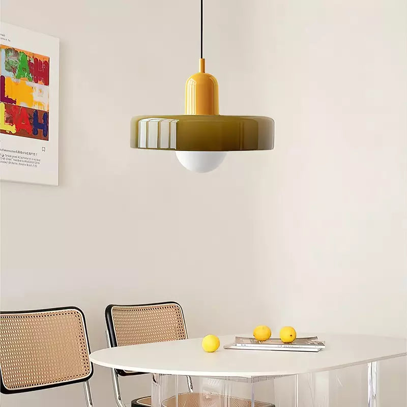Hanglamp met gele fitting boven een witte ovale eettafel met citroenen 18