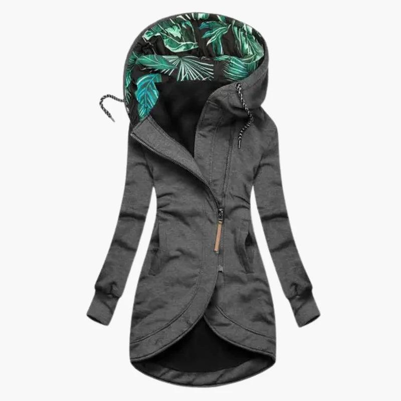 Donkergrijze versie van de jas met schuine rits, afgeronde zoom en capuchon met groen bladerenprint aan de binnenkant. 2