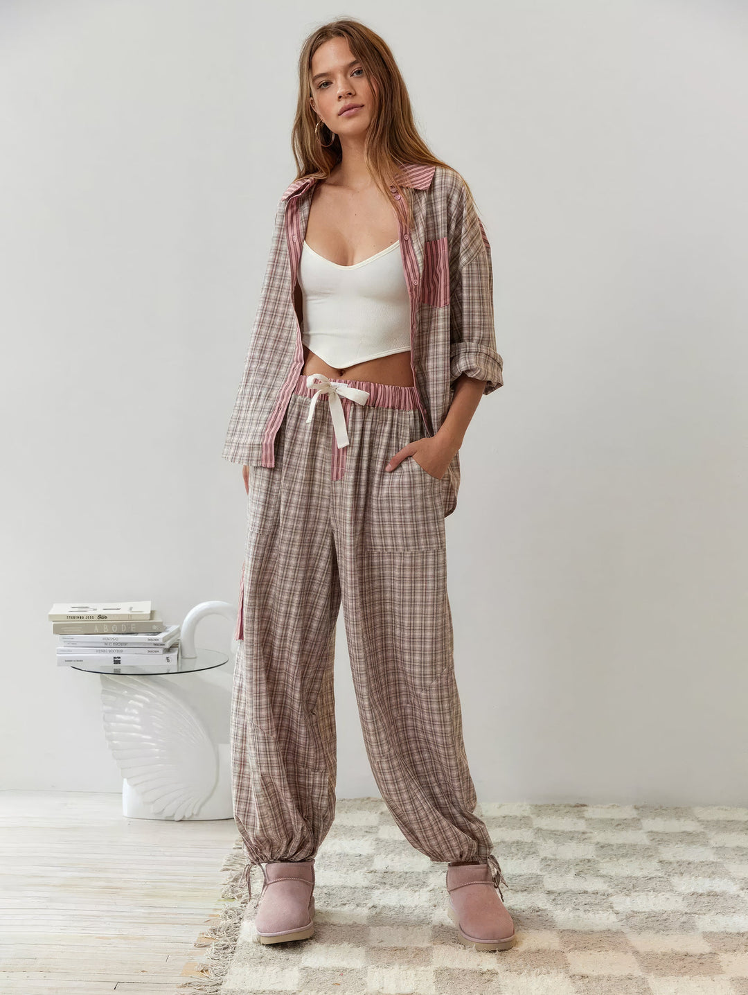 Model in het geruite setje met open overhemd over een wit topje en een wijde broek met koord in de taille en strikbandjes aan de enkels. 6