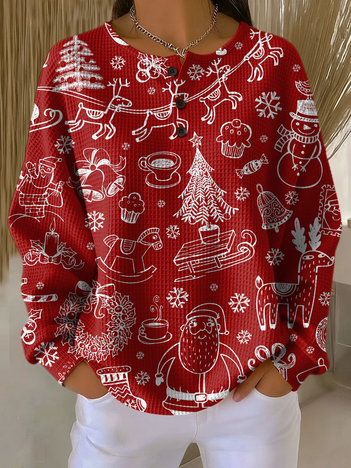 Rode wafeltrui met knoopsluiting aan de hals en witte kerstprint met kerstman, rendieren, sneeuwpop en kerstbomen, gedragen met witte broek. 21