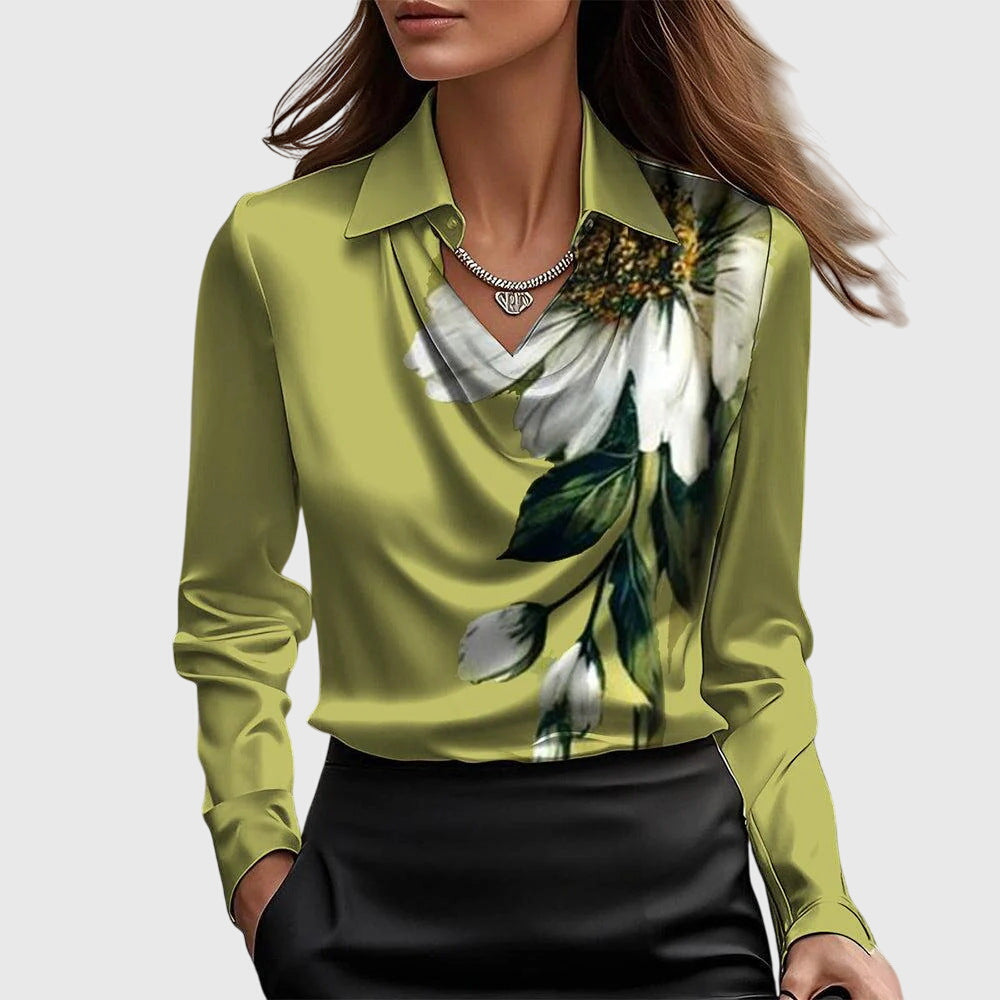 Model draagt de groene blouse met grote witte bloemprint met bladeren, gedrapeerde hals en een zwarte rok. 7