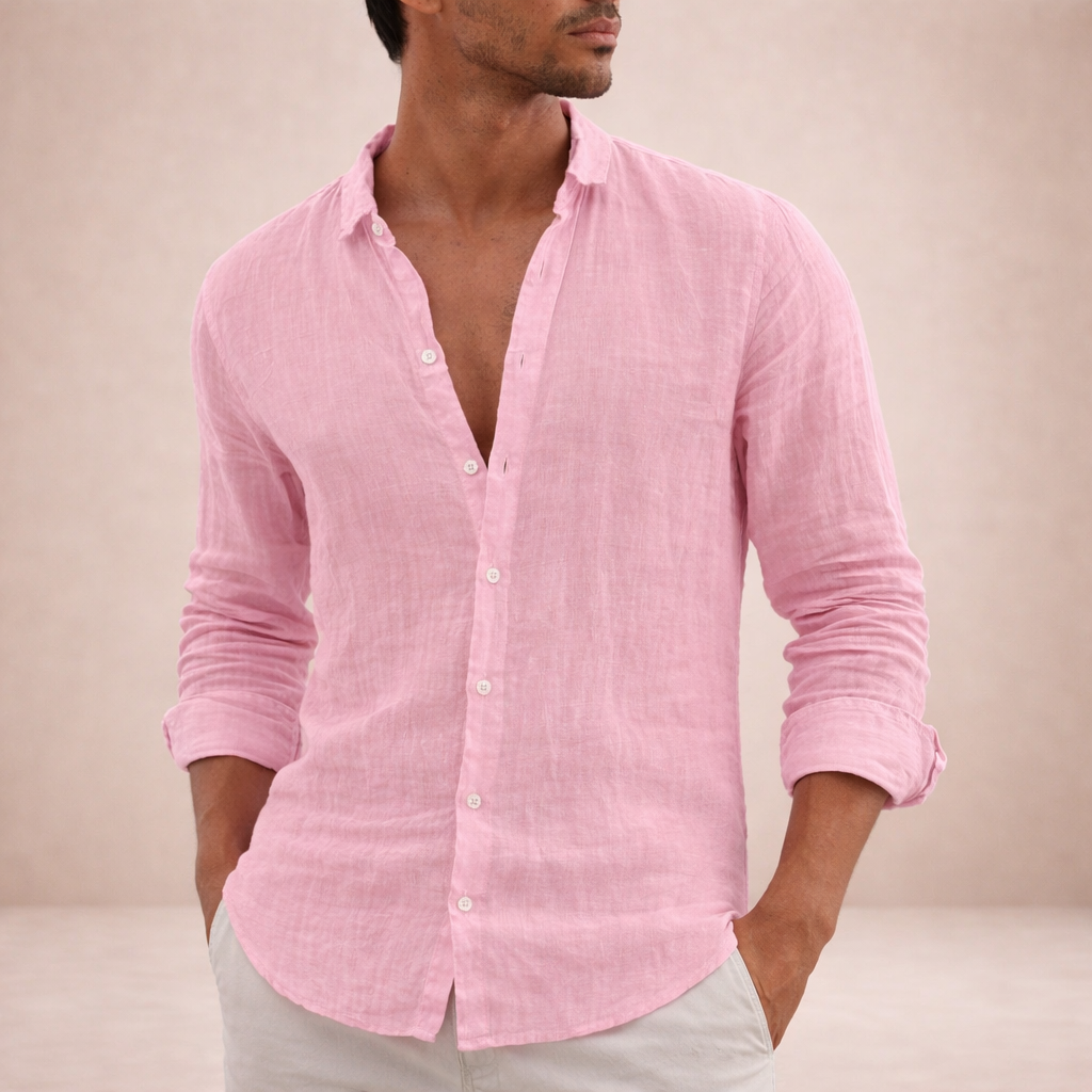 Model draagt roze linnen overhemd met opgerolde mouwen en beide handen in de zakken van een lichte broek. 4