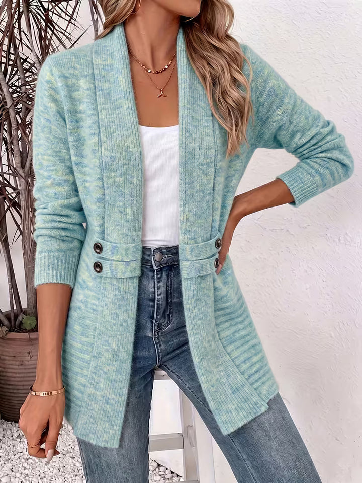 Model in gemêleerd turkoois vest met sjaalkraag en twee knoopbandjes, hand op de heup, met spijkerbroek 5