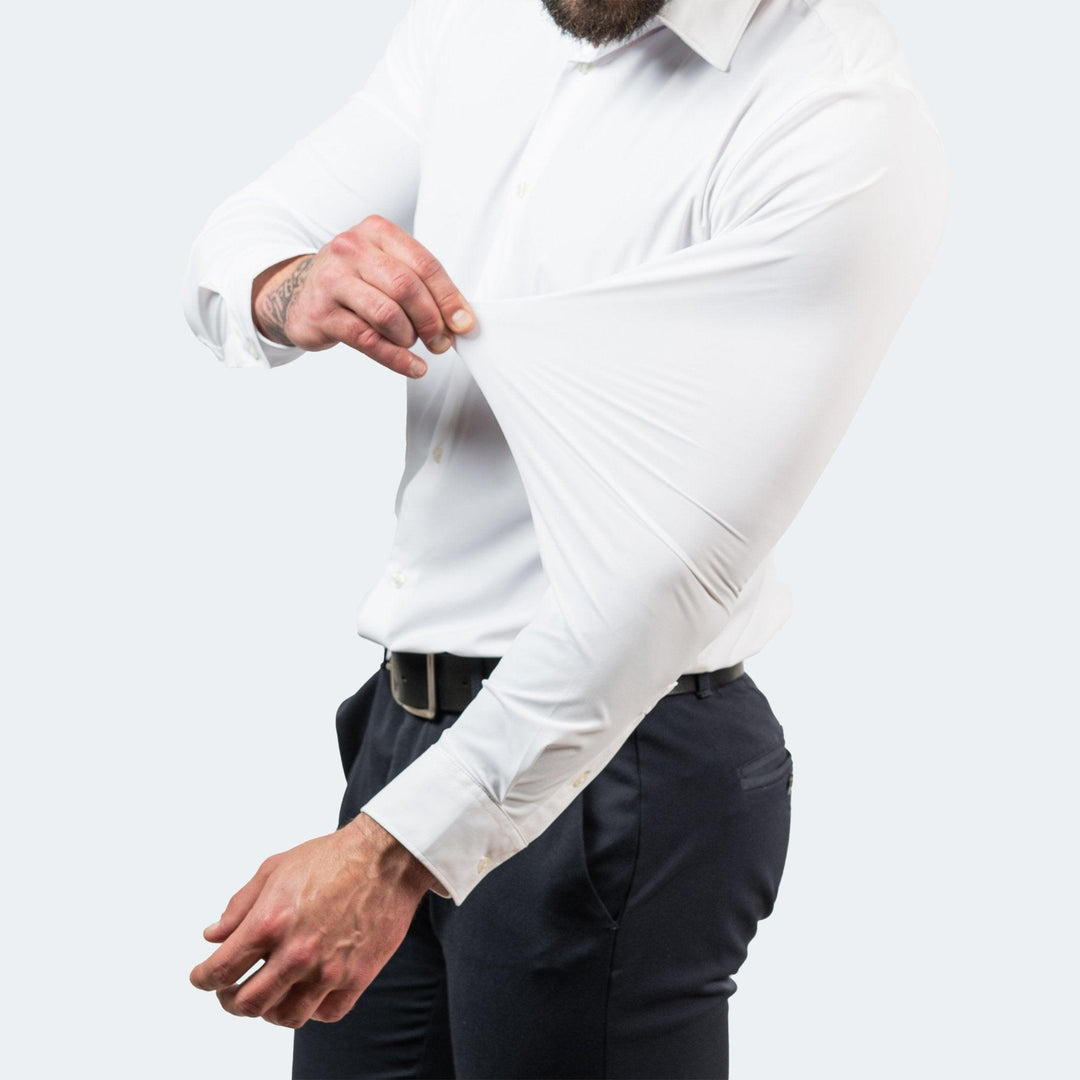 Wit overhemd gedragen door een man die de mouw omhoog trekt om te laten zien hoe soepel de stof meegeeft. 4