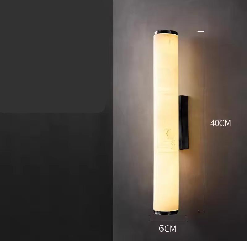 Brandende cilindrische marmeren wandlamp tegen een donkere muur, met maatlijnen die een hoogte van 40 cm en een breedte van 6 cm tonen. 22