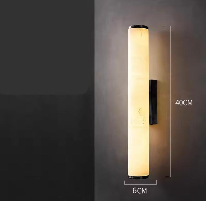 Brandende cilindrische marmeren wandlamp tegen een donkere muur, met maatlijnen die een hoogte van 40 cm en een breedte van 6 cm tonen. 22
