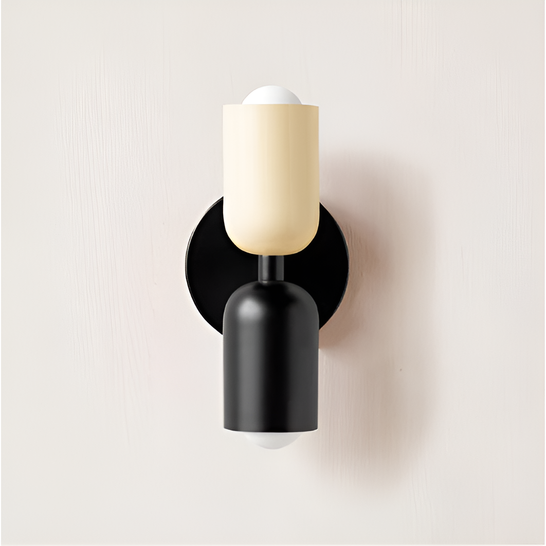 Wandlamp met crèmekleurige bovenkap en zwarte onderkap op een zwarte ronde plaat, tegen een lichte muur. 31