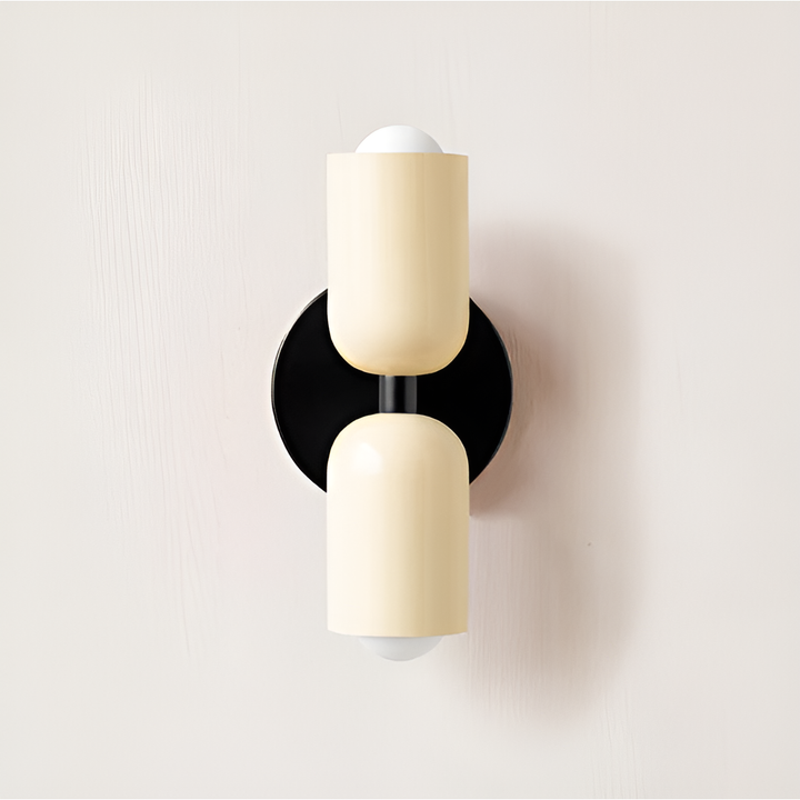 Wandlamp met twee crèmekleurige lichtkoppen op een zwarte ronde wandplaat, tegen een lichte muur. 36