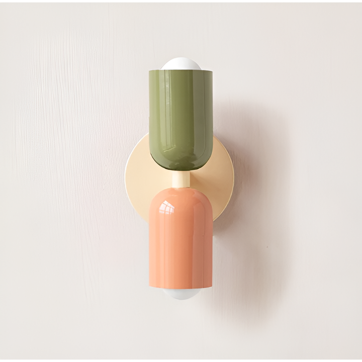 Wandlamp met groene bovenste lichtkop en perzikkleurige onderste lichtkop op een crèmekleurige ronde wandplaat. 14