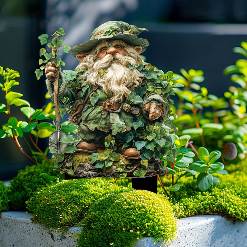 Tuinkabouter met schep en klimop, geplaatst op groene mosbulten en tussen plantjes in een stenen bak. 13