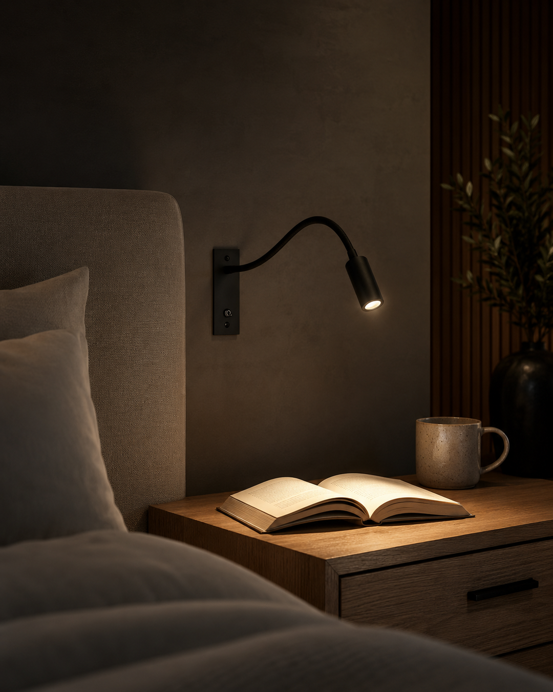 Zwarte zwanenhalslamp verlicht in een donkere slaapkamer een opengeslagen boek op het houten nachtkastje, naast een mok. 6