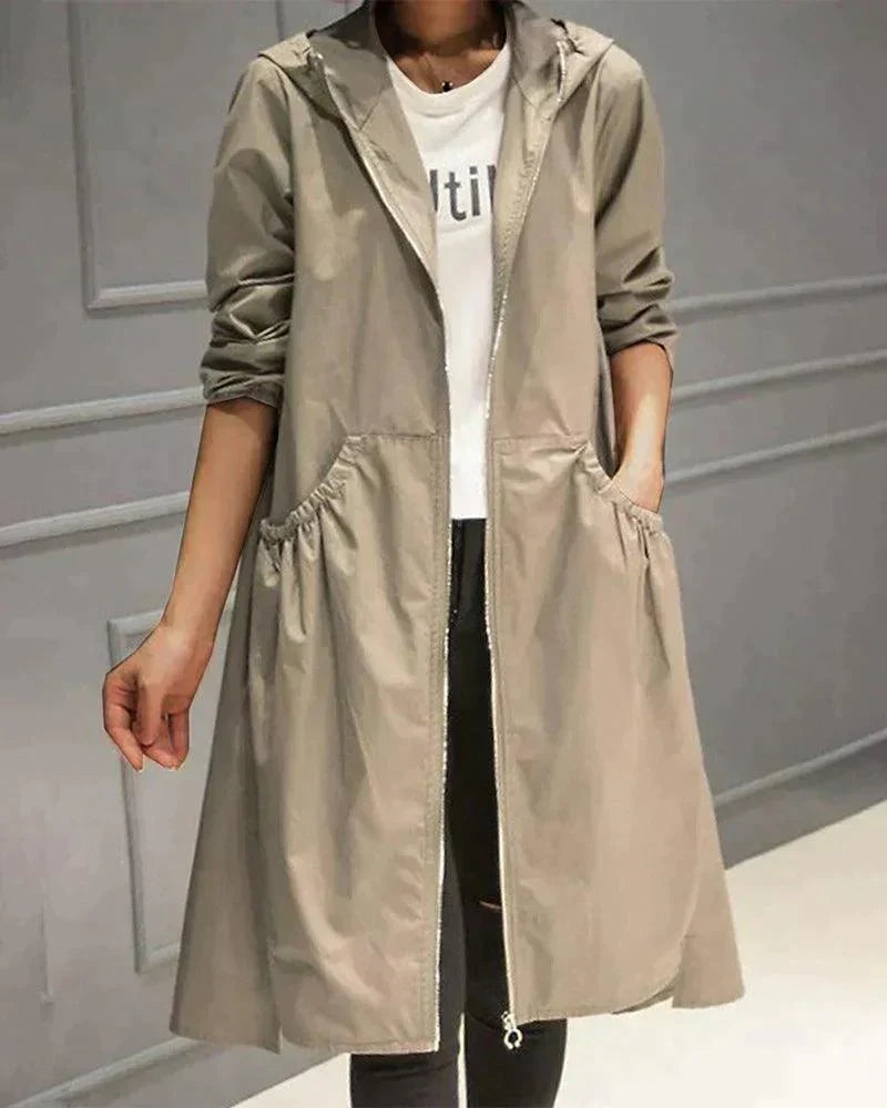 Open lange regenjas in beige met capuchon en plooizakken, gedragen over wit shirt, vooraanzicht 1