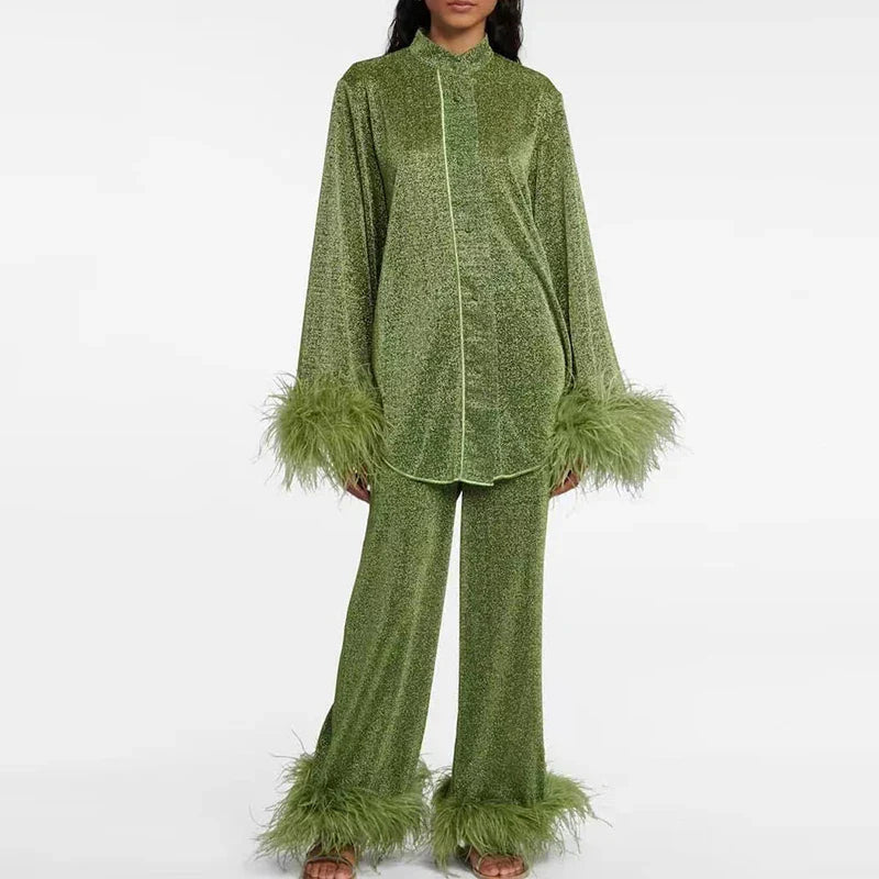 Model toont de olijfgroene glitterset met lange blouse, lichte bies, wijde broek en veerrand aan manchetten en broekzoom. 4