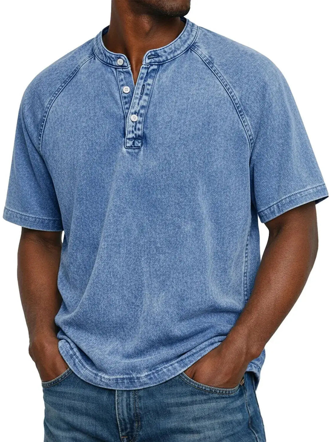 Man draagt het gewassen Henley-shirt met korte raglanmouwen in lichtblauw, gecombineerd met een spijkerbroek. 2